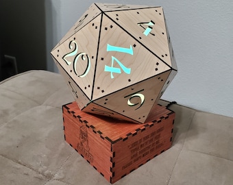 May include: A wooden 20-sided die with a light blue glow, sitting on a wooden base with an inscription. The inscription reads "There is a place in this world for all of us, even if it is just in the hearts of those who love us."