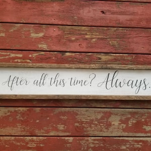 May include: A white wooden sign with a brown wood frame. The sign has black calligraphy that reads "After all this time? Always."