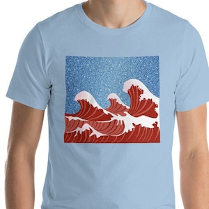 May include: A light blue t-shirt with a red and white wave design on the front. The wave design is set against a blue background with white speckles.
