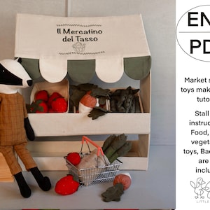 May include: A fabric market stall with a sign that reads "Il Mercatino del Tasso". The stall is filled with toy produce, including red tomatoes, green vegetables, and a toy badger. The image includes the text "ENG PDF".