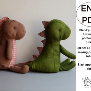 May include: Two stuffed dinosaur toys. One is brown with pink and white checkered accents, the other is green with pink accents. The image includes text that says "ENG PDF" and "30 cm EFI Dinosaur sewing pattern and tutorial."
