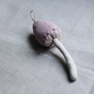 Puede incluir: Un hongo de tela rosa con un tallo blanco. El hongo est&aacute; decorado con peque&ntilde;os puntos blancos.