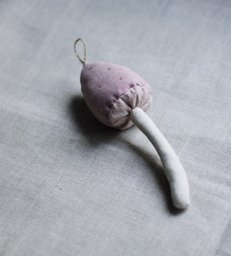 Puede incluir: Un hongo de tela rosa con un tallo blanco. El hongo est&aacute; decorado con peque&ntilde;os puntos blancos.