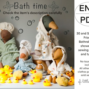 May include: A sewing pattern for a bathrobe and shower cap for 30 and 55 cm dolls. The pattern includes a tutorial and is for the "EFI Friends" line of dolls. The image shows three dolls wearing bathrobes and shower caps, along with rubber duckies and bath toys.