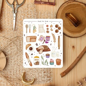 Könnte beinhalten: Ein Bogen Sticker mit verschiedenen Back- und Küchenutensilien, darunter Brot, Mehl, Milch, Kekse und ein Nudelholz. Die Sticker sind im Aquarell-Stil mit weißem Hintergrund und schwarzen Umrissen illustriert. Der Text "FRAI.th Shop" befindet sich oben auf dem Bogen.
