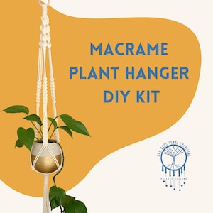 May include: A cream-colored macrame plant hanger DIY kit with a gold and white ceramic pot holding a green leafy plant. The text "MACRAME PLANT HANGER DIY KIT" is displayed in blue. The logo for "Grá Agus Sonas Creations" is in the bottom right.