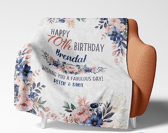 May include: A white throw blanket with a floral design in shades of blue, pink, and green. The blanket has the text "Happy 70th Birthday Brenda! Wishing you a fabulous day! Peter & Sara" printed on it.