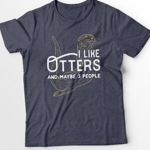 May include: A navy blue t-shirt with a graphic of an otter and the text "I like otters and maybe 3 people".