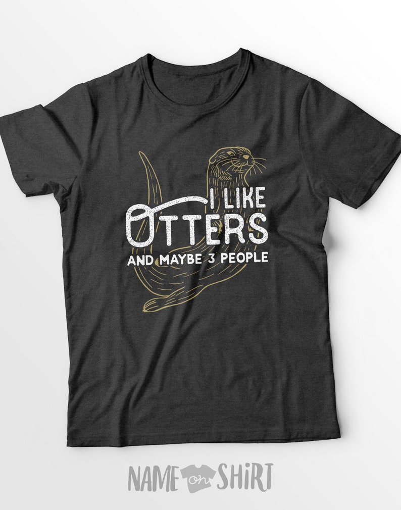 May include: A dark grey t-shirt with a graphic of an otter and the text "I like otters and maybe 3 people".