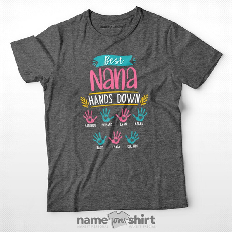 May include: A gray t-shirt with the text "Best Nana Hands Down" in pink, yellow, and blue. There are seven handprints with names below each handprint: Madison, Richard, Evan, Kaleb, Zack, Tracy, and Colton.
