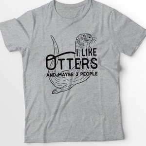 May include: Gray t-shirt with a black and white illustration of an otter. The text "I like otters and maybe 3 people" is printed on the shirt.