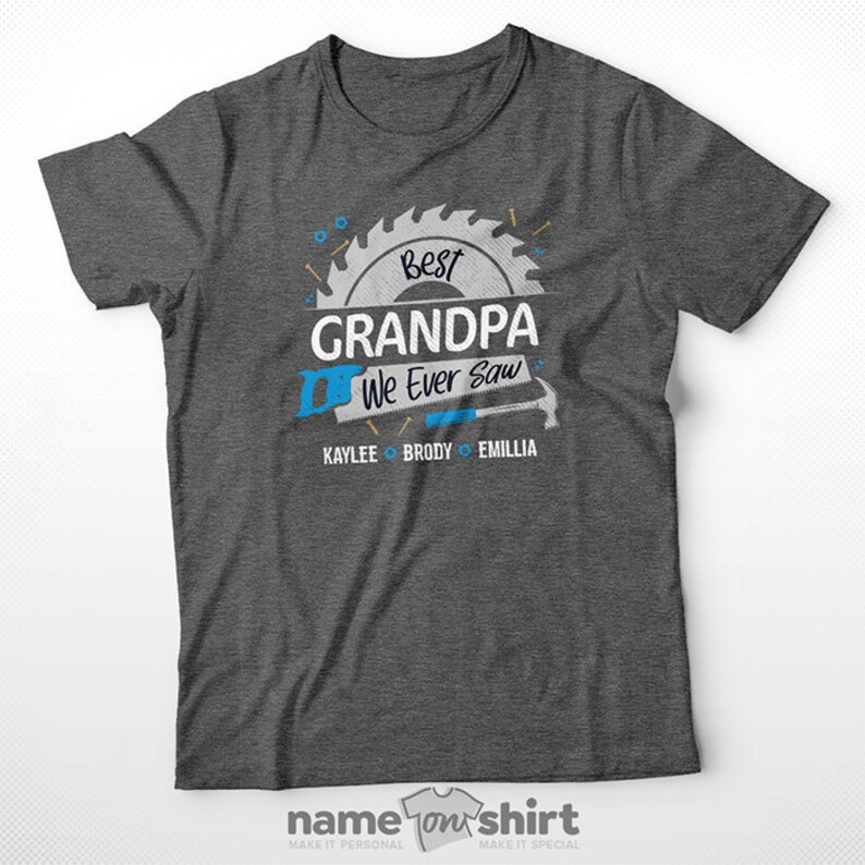 Pu&ograve; includere: Maglietta grigia con un design a forma di lama da sega che dice "Best Grandpa We Ever Saw" con i nomi Kaylee, Brody ed Emillia sotto.