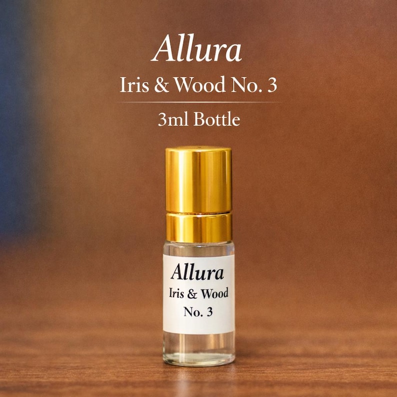 May include: A small perfume bottle with a gold cap and a white label. The label reads "Allura Iris & Wood No. 3". The bottle contains a clear liquid and is a 3ml bottle. The background is a warm brown colour.