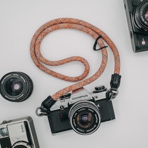 Correa de cámara de cuerda con liberación rápida. Longitud fija. Suave y colorida. Sujeción y protección de cuero.