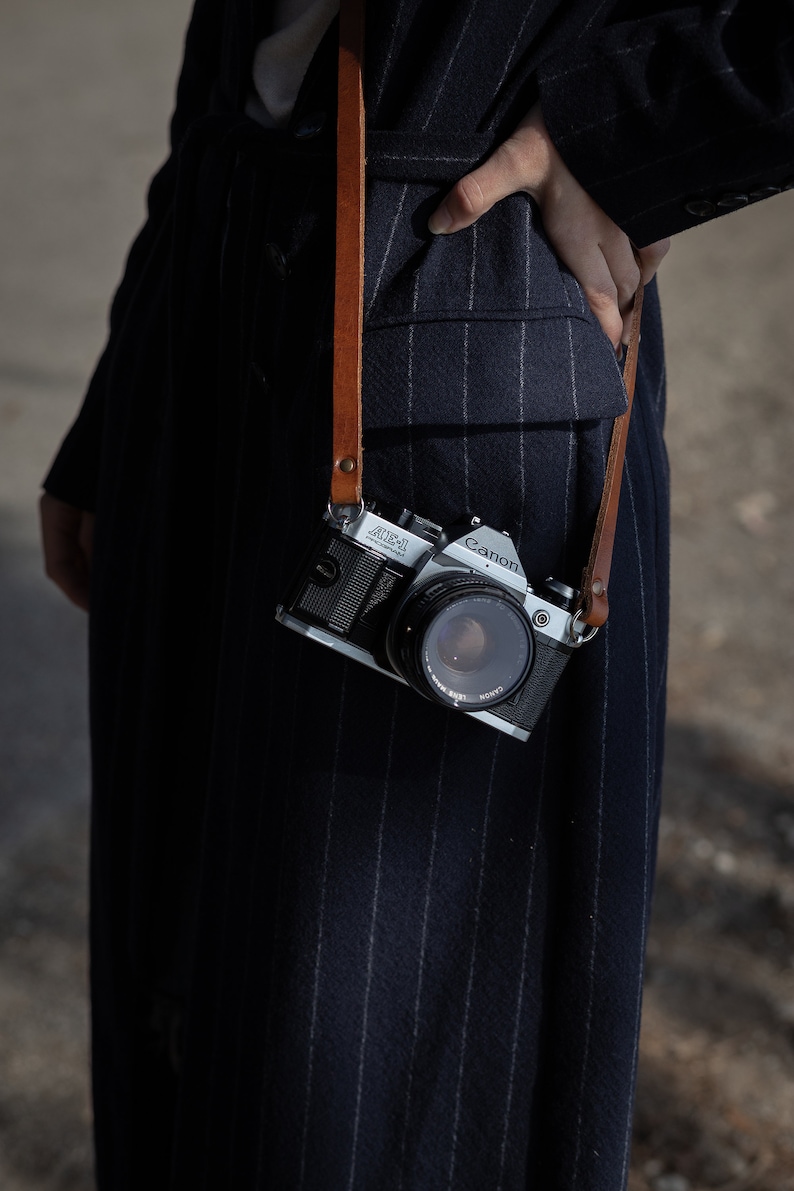 Tracolla in pelle per fotocamera. Compatibile con fotocamere Leica, canon, Nikon, fuji Sony e tutte le fotocamere vintage a pellicola. Fatta a mano in Italiana. Vera pelle conciata al vegetale italiana.