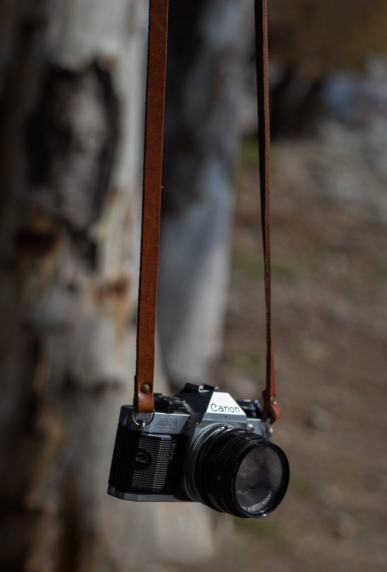 Tracolla in pelle per fotocamera. Compatibile con fotocamere Leica, canon, Nikon, fuji Sony e tutte le fotocamere vintage a pellicola. Fatta a mano in Italiana. Vera pelle conciata al vegetale italiana.