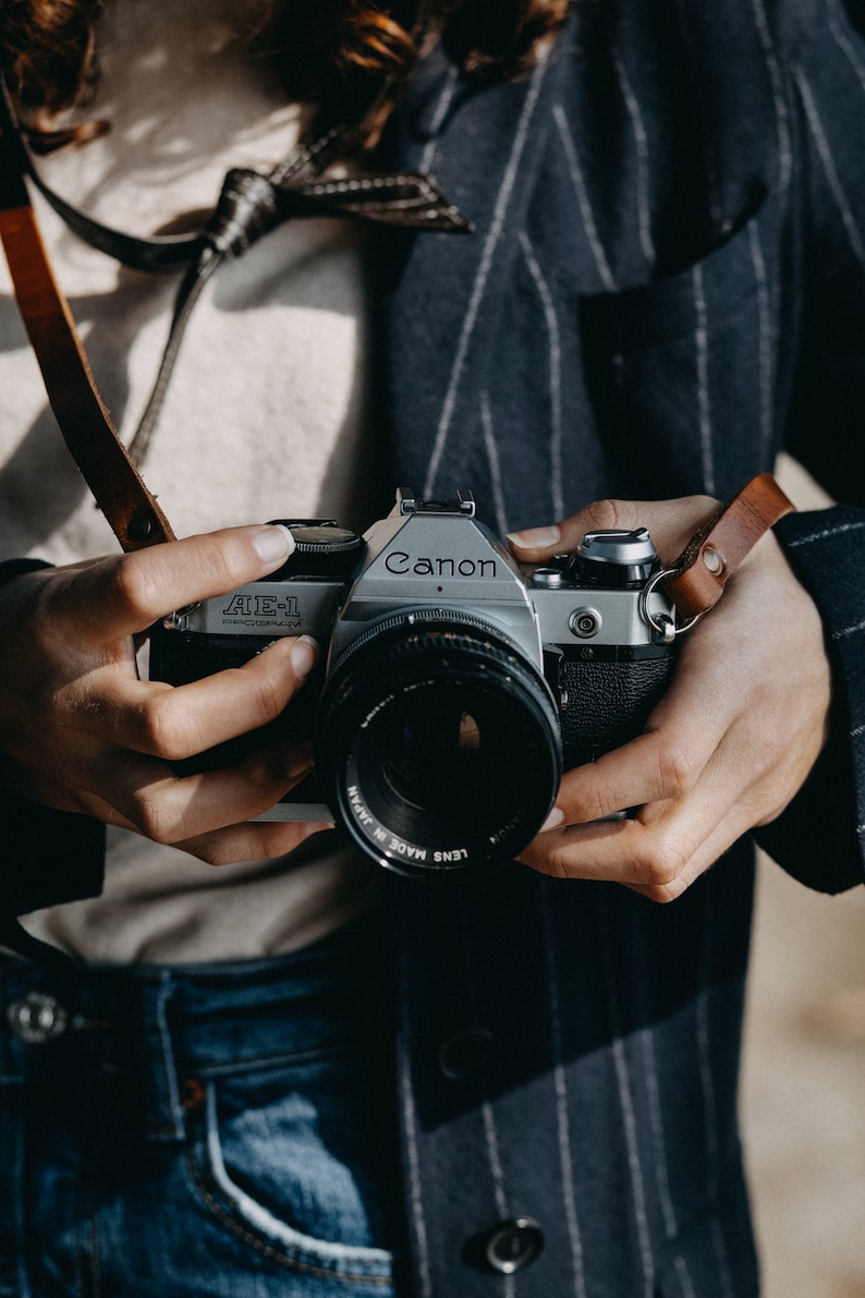 Tracolla in pelle per fotocamera. Compatibile con fotocamere Leica, canon, Nikon, fuji Sony e tutte le fotocamere vintage a pellicola. Fatta a mano in Italiana. Vera pelle conciata al vegetale italiana.