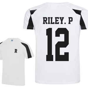May include: White athletic shirt with black shoulder and sleeve accents. The back of the shirt displays the name "RILEY. P" above the number "12" in black block letters. A smaller version of the shirt shows the letter "R" on the chest.