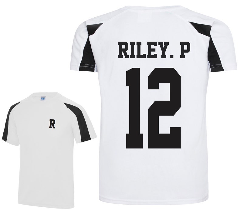 May include: White athletic shirt with black shoulder and sleeve accents. The back of the shirt displays the name "RILEY. P" above the number "12" in black block letters. A smaller version of the shirt shows the letter "R" on the chest.