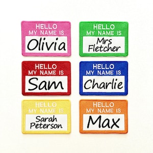 May include: Six rectangular embroidered patches in pink, green, red, blue, yellow, and orange. Each patch features the white text HELLO MY NAME IS above a white centre panel with black embroidered names: Olivia, Mrs Fletcher, Sam, Charlie, Sarah Peterson, and Max.
