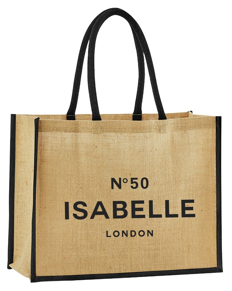 May include: A beige jute tote bag with black handles and trim. The bag has the text "N&deg;50 ISABELLE LONDON" printed on the front.
