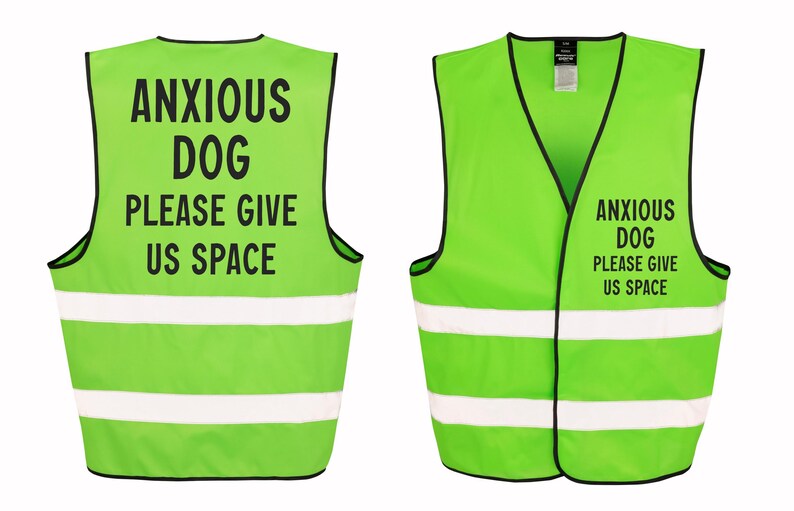 May include: Lime green dog vest with black trim and white reflective stripes. The vest has the text "ANXIOUS DOG PLEASE GIVE US SPACE" printed in black. The vest is designed to alert others to a dog's anxiety.