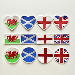 May include: A selection of embroidered patches displaying the flags of Wales, Scotland, England, and the United Kingdom. The patches are in heart, rectangular, and circular shapes, with red, white, blue, and green colours.