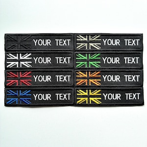 May include: A selection of black rectangular patches featuring embroidered Union Jack flags in different colors. Each patch has the text "YOUR TEXT" in white. The flags are in black, white, green, red, orange, blue, and yellow.