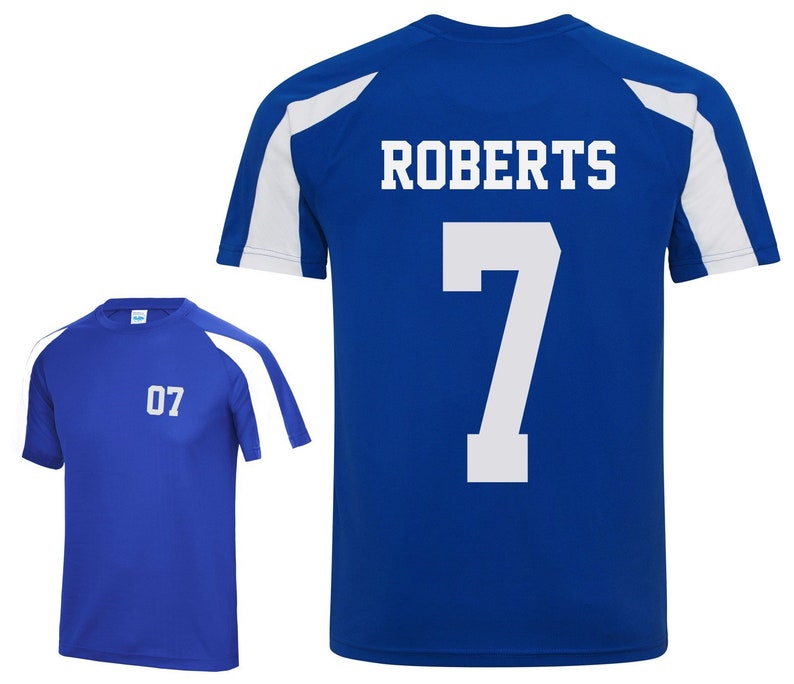 May include: Two blue athletic shirts. One shirt has the number "07" on the front. The other shirt has the name "ROBERTS" and the number "7" on the back. Both shirts have white accents on the shoulders and sleeves.