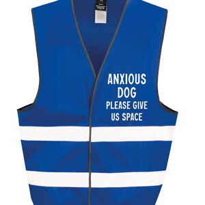 May include: A blue safety vest with white reflective stripes and the text "ANXIOUS DOG PLEASE GIVE US SPACE" in white. The vest has a V-neck and a gray trim. The vest is designed for dogs.