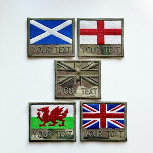 May include: Five embroidered patches displaying flags of the UK, Scotland, England, and Wales. Each patch has a camouflage border and the text "YOUR TEXT" below the flag design. The flags are in their respective colors.