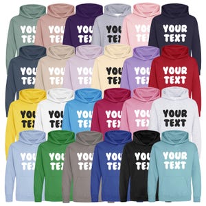 May include: A selection of hooded sweatshirts in a range of colours, such as green, pink, and blue. Each sweatshirt displays the text "YOU TEXT" or "YOUR TEXT" in a bold, white font. The hoodies are presented in a studio setting.