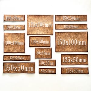 May include: A collection of rectangular brown faux leather patches with textured surfaces. Each patch features white embroidered text indicating its dimensions in millimetres, including 100x30mm, 100x25mm, 100x100mm, 125x25mm, 150x50mm, 125x100mm, 100x50mm, 80x50mm, 80x30mm, 80x25mm, 150x30mm, 150x25mm, 150x100mm, 125x50mm, and 125x30mm.