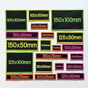 May include: A collection of rectangular black fabric patches with embroidered borders and text in neon green, pink, or orange. Each patch displays its specific dimensions in millimetres, ranging from 40x25mm to 150x100mm, arranged in a grid.
