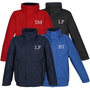 May include: Four waterproof jackets in red, black, navy, and blue. Each jacket features a high collar, a zip, and white initials on the chest. These jackets are designed for outdoor wear and protection from the elements.