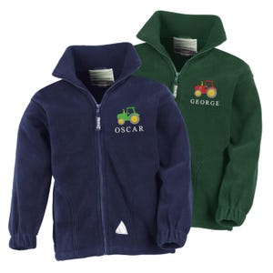 May include: Two fleece zip-up jackets, one navy blue and one dark green. Each jacket has a tractor graphic and a name embroidered below. The navy jacket has a green tractor and the name "OSCAR". The green jacket has a red tractor and the name "GEORGE".