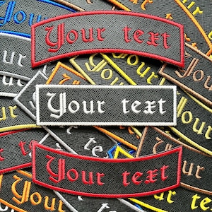 May include: A collection of embroidered patches, each featuring the text "Your text". The patches are in various shapes, including rectangular and arched. The patches are black with red or white lettering and borders. The background is a mix of other patches.