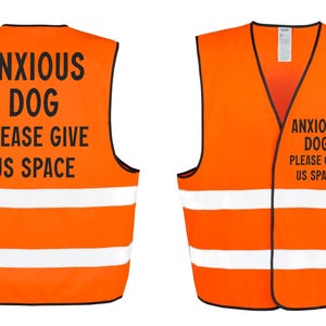May include: Two orange safety vests with black trim and white reflective stripes. The vests have the text "ANXIOUS DOG PLEASE GIVE US SPACE" printed in black. One vest is shown from the front and the other from the back.