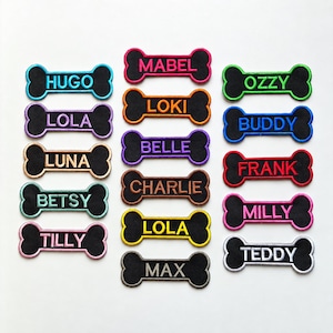 May include: A collection of bone-shaped embroidered patches with black centers and colorful borders. Each patch features a name stitched in matching thread, including Hugo, Lola, Luna, Betsy, Tilly, Mabel, Loki, Belle, Charlie, Lola, Max, Ozzy, Buddy, Frank, Milly, and Teddy.
