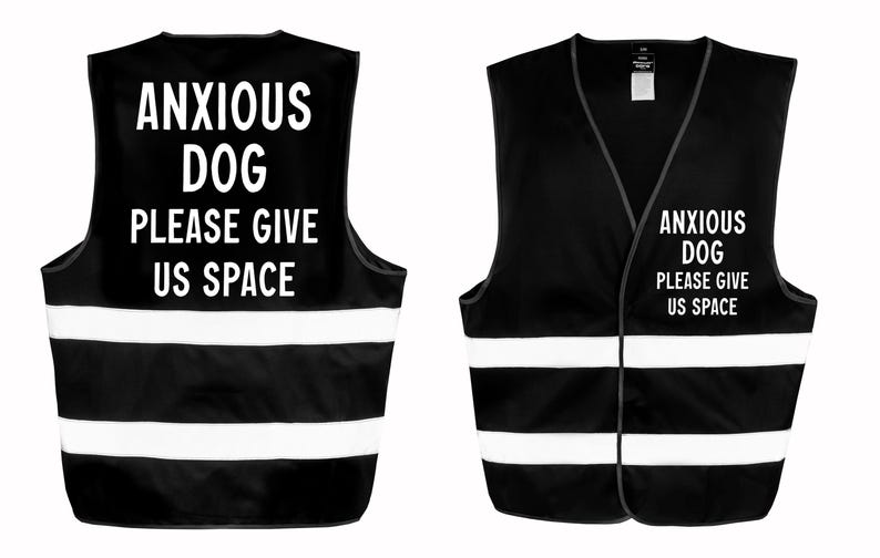 May include: Black vest with white reflective stripes and the text "ANXIOUS DOG PLEASE GIVE US SPACE" in white. The vest is designed to be worn by a dog. The image shows the front and back of the vest.