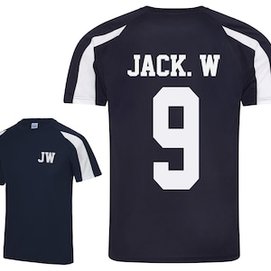 May include: Navy blue athletic t-shirt with white accents on the sleeves and shoulders. The back of the shirt displays the name "JACK. W" above the number "9" in white. The front of the shirt has the initials "JW" in white.