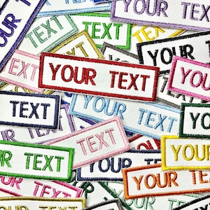 May include: A selection of embroidered patches, each displaying the words "YOUR TEXT" and "TEXT". The patches feature white fabric with colourful borders in shades like red, pink, and green. The text is embroidered in a contrasting colour to the border.