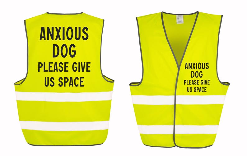 May include: Two neon yellow dog vests with reflective white stripes. The vests have black text that reads "ANXIOUS DOG PLEASE GIVE US SPACE". One vest is shown from the front and the other from the back.
