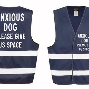 May include: Navy blue dog vest with white reflective stripes and the text "ANXIOUS DOG PLEASE GIVE US SPACE" in white. The vest has a V-neck design and is designed to be worn by a dog.
