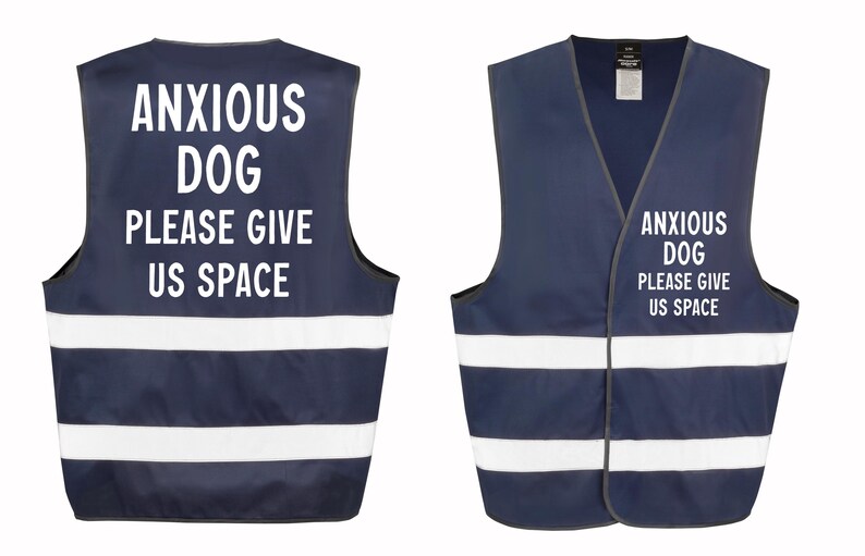 May include: Navy blue dog vest with white reflective stripes and the text "ANXIOUS DOG PLEASE GIVE US SPACE" in white. The vest has a V-neck design and is designed to be worn by a dog.