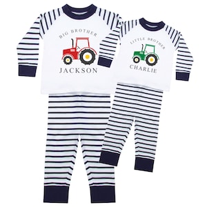 May include: Two sets of children's pajamas. One set features a red tractor graphic with "BIG BROTHER" and the name "JACKSON" printed on the white top. The other set has a green tractor graphic with "LITTLE BROTHER" and the name "CHARLIE". Both sets have navy and white striped pants.