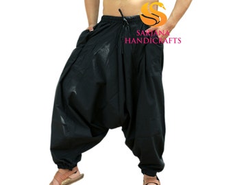 May include: A black pair of loose-fitting pants with a drawstring waist. The pants are made of a soft, comfortable fabric and have a relaxed fit. The pants are called "Sarjana Handicrafts".