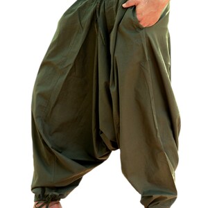 May include: Olive green loose-fitting pants with a drawstring waist and elastic cuffs. The pants are made of a soft, comfortable fabric and have a relaxed fit.