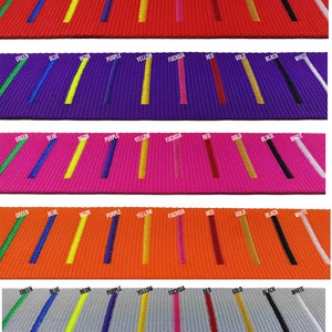 collection of luggage straps laid out in rows, each in a different vibrant colour with a variety of coloured embroidered stripes .  straps demonstrates the customization options available for personalized luggage identification.