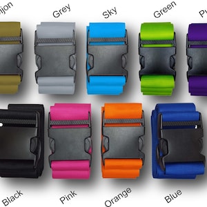 The image displays a variety of luggage straps with buckles. Each strap is a different colour
